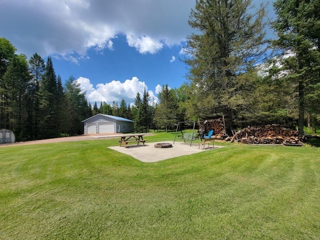 view of yard with a garage, an outbuilding, and an outdoor fire pit