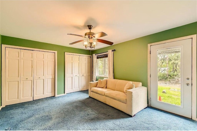 living area featuring carpet, ceiling fan, and a healthy amount of sunlight