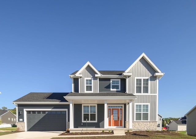 craftsman-style house featuring covered porch, a front yard, and a garage