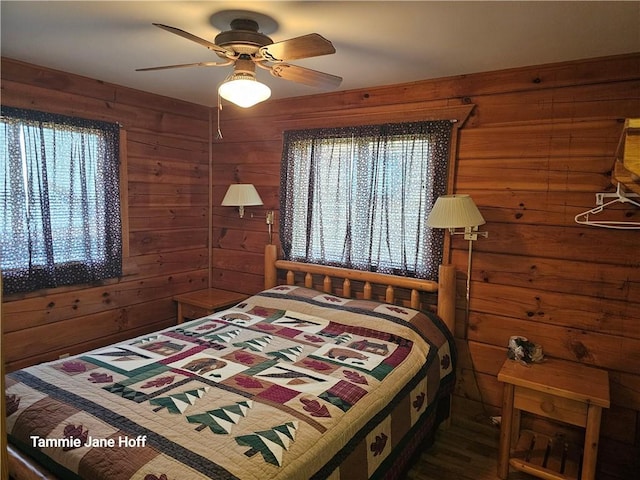 bedroom with ceiling fan and wooden walls