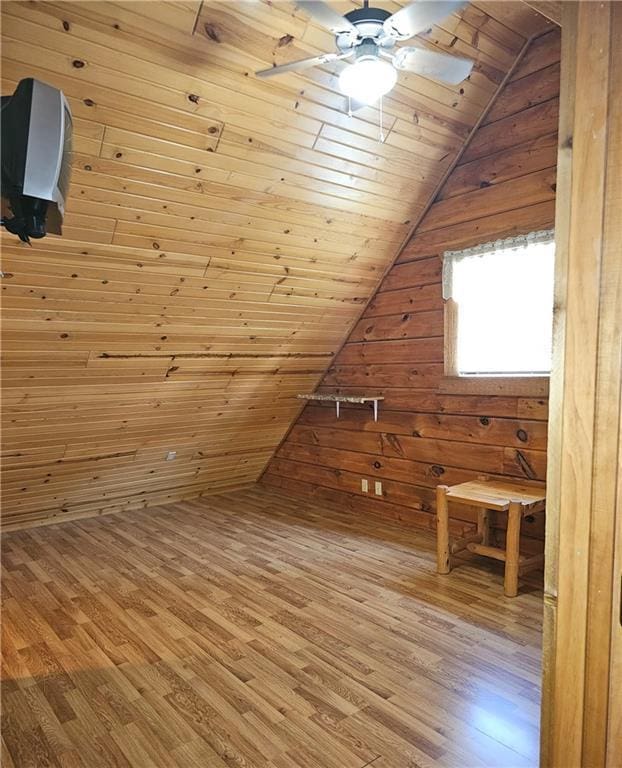 additional living space with hardwood / wood-style floors, wooden walls, vaulted ceiling, and wooden ceiling