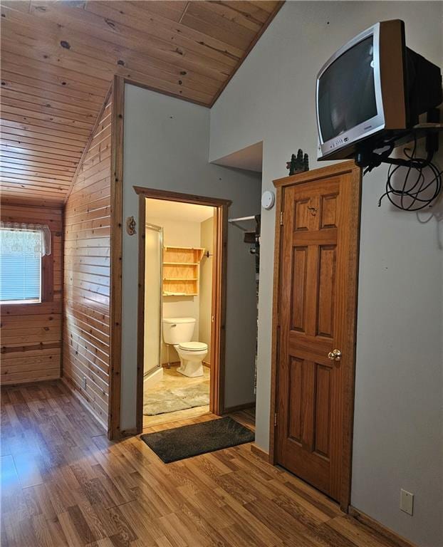 corridor with wood walls, hardwood / wood-style floors, wood ceiling, and vaulted ceiling