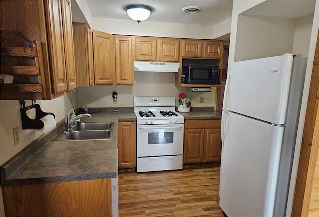 kitchen with white appliances, sink, and light hardwood / wood-style flooring