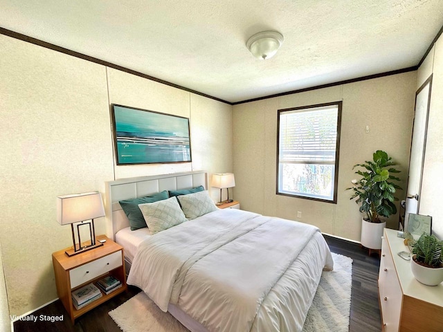 bedroom with dark wood-type flooring, a textured ceiling, and ornamental molding