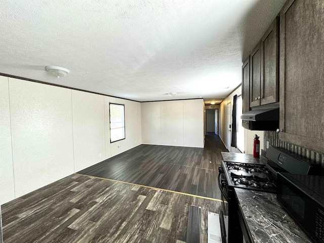 kitchen featuring a textured ceiling, dark brown cabinetry, dark hardwood / wood-style floors, and black appliances