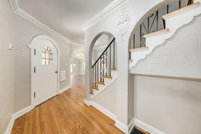 entrance foyer with wood-type flooring and ornamental molding