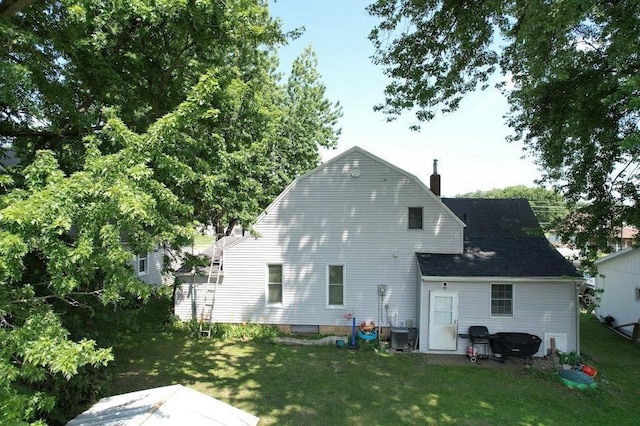 back of property featuring a lawn and central AC