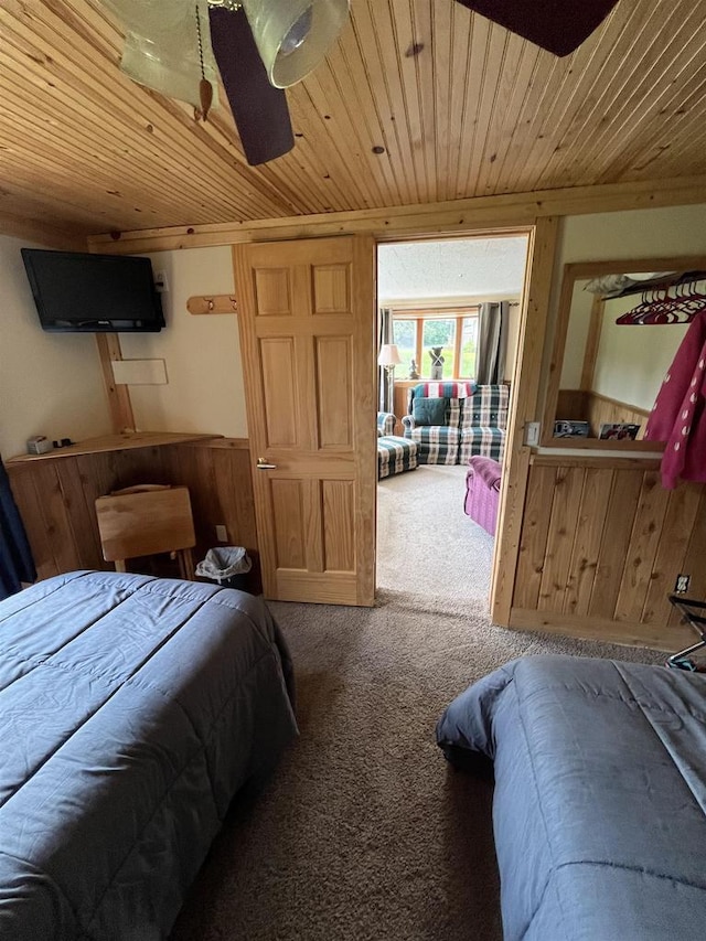 bedroom with carpet flooring, wooden walls, and wood ceiling