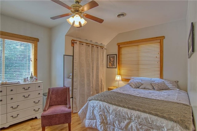 bedroom featuring ceiling fan, light hardwood / wood-style floors, and lofted ceiling