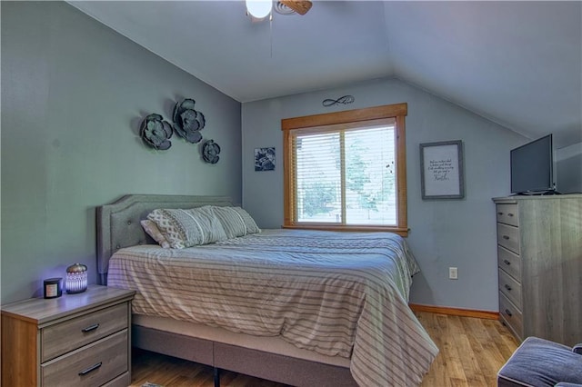 bedroom featuring ceiling fan, light hardwood / wood-style flooring, and vaulted ceiling