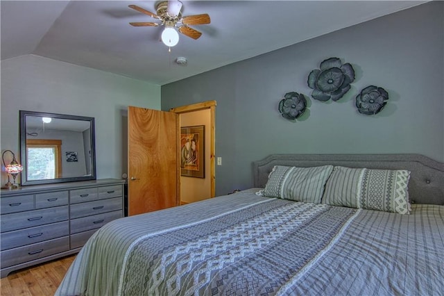 bedroom with hardwood / wood-style floors, ceiling fan, and vaulted ceiling