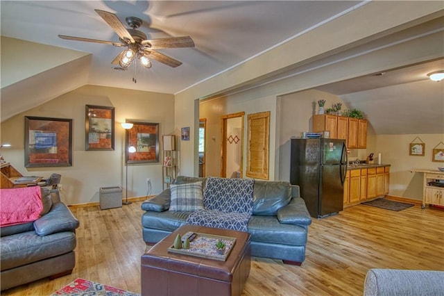 living room featuring ceiling fan, lofted ceiling, and light wood-type flooring