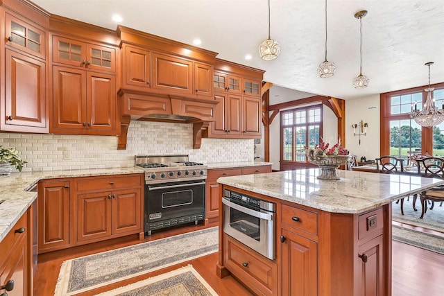 kitchen with dark wood-type flooring, an inviting chandelier, hanging light fixtures, a kitchen island, and premium stove