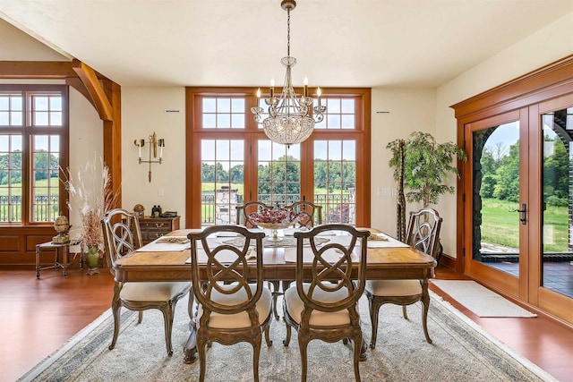 dining room featuring a chandelier, french doors, plenty of natural light, and dark wood-type flooring