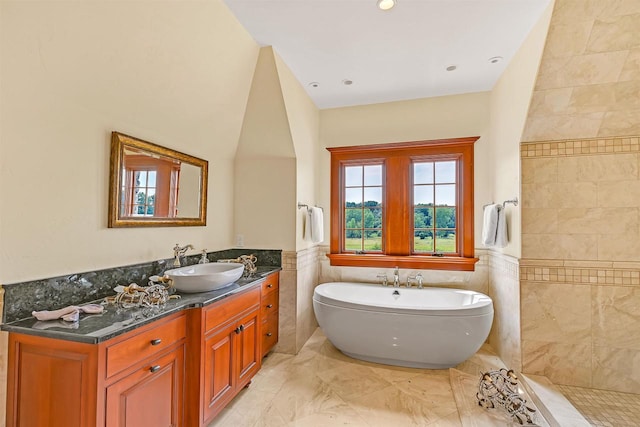 bathroom featuring a bathing tub, vanity, and tile walls