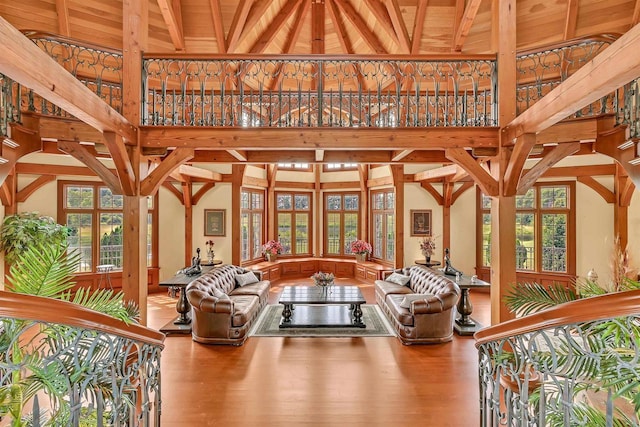 unfurnished living room featuring beam ceiling, high vaulted ceiling, wooden ceiling, and wood-type flooring