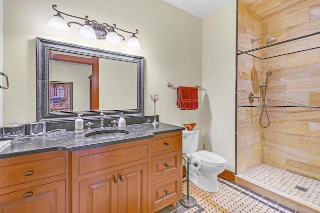 bathroom featuring vanity, toilet, and a tile shower