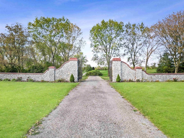 view of gate with a lawn