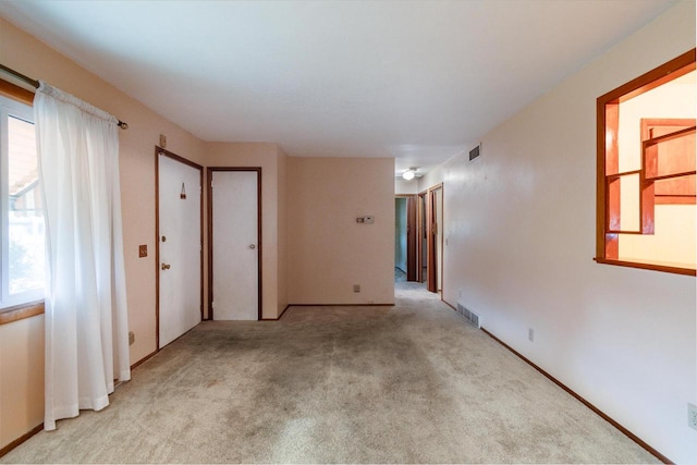 unfurnished room featuring light colored carpet