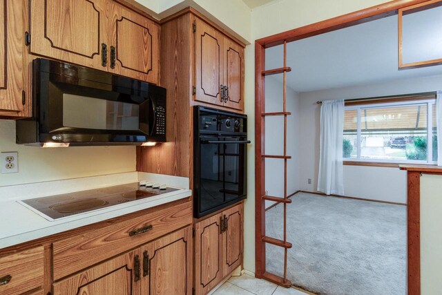 kitchen featuring light colored carpet and black appliances