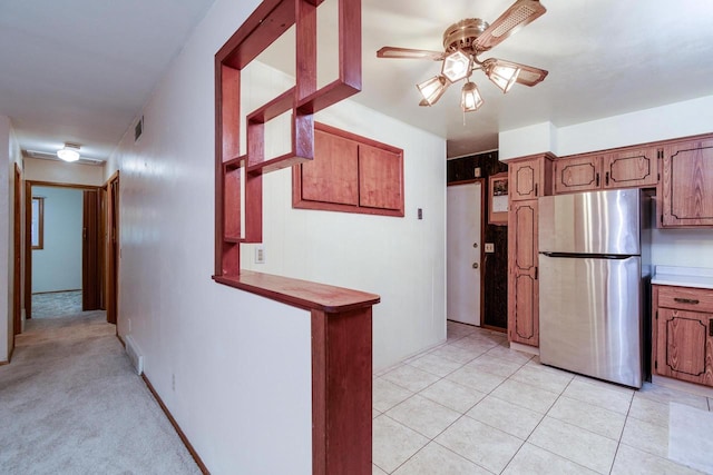 kitchen with ceiling fan, light tile patterned floors, and stainless steel refrigerator