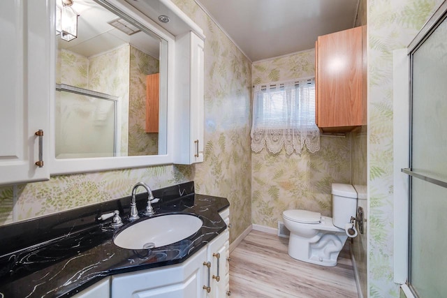 bathroom featuring hardwood / wood-style floors, vanity, toilet, and walk in shower