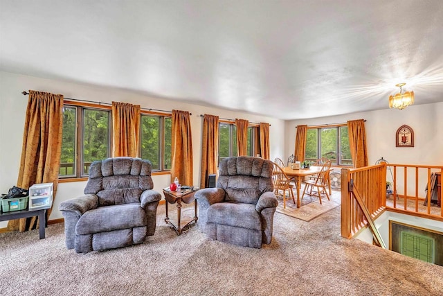 carpeted living room with an inviting chandelier