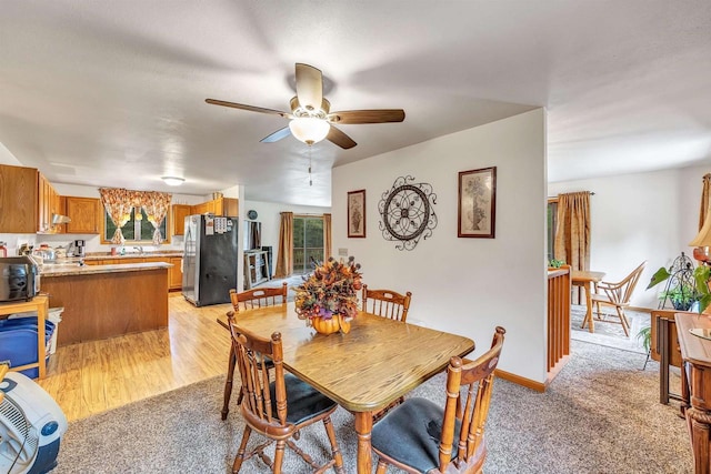 dining room featuring ceiling fan and light carpet