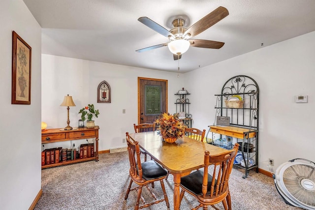 carpeted dining space with ceiling fan