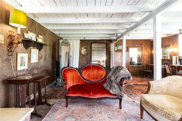 sitting room featuring beamed ceiling, wood walls, and wooden ceiling