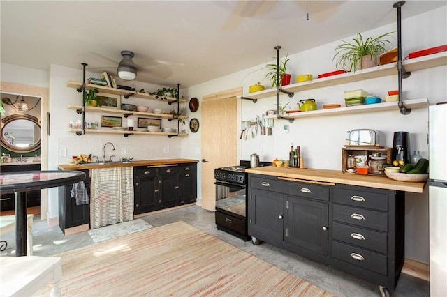 kitchen with ceiling fan, decorative backsplash, black electric range, and sink