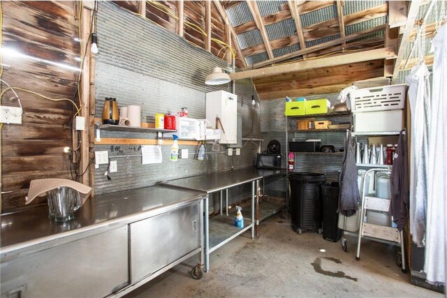 kitchen with vaulted ceiling, concrete floors, and white cabinets