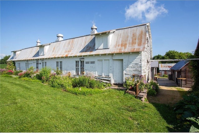 rear view of property featuring a lawn