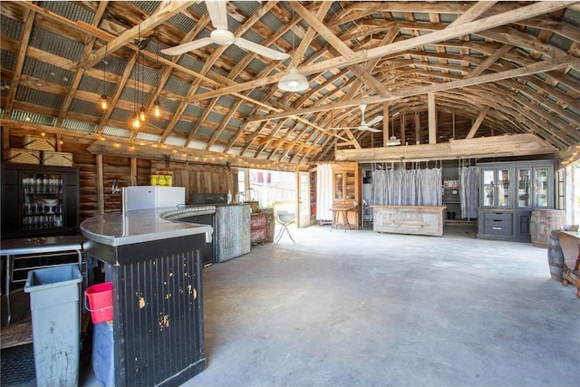 miscellaneous room with ceiling fan, concrete floors, plenty of natural light, and high vaulted ceiling