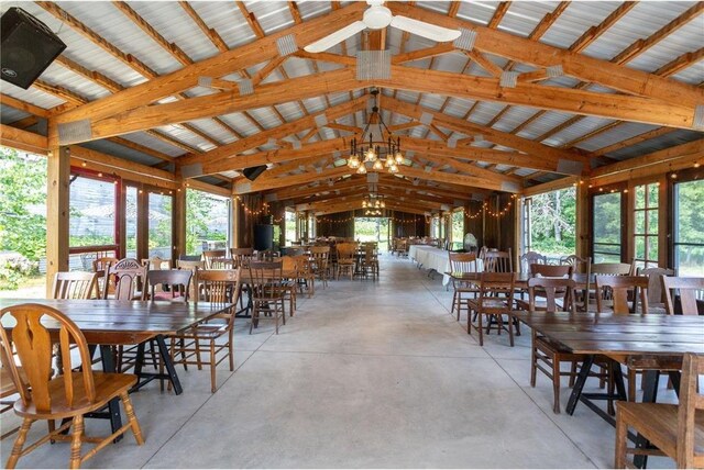 dining space with high vaulted ceiling, beam ceiling, and an inviting chandelier