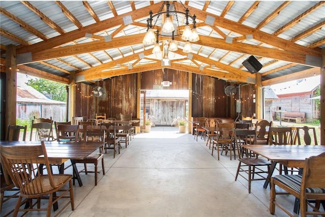 dining area featuring beam ceiling, high vaulted ceiling, wooden walls, and a notable chandelier