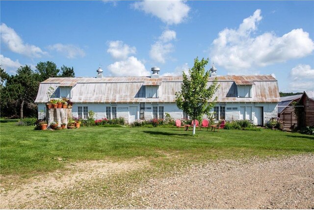 rear view of property featuring a yard and an outdoor structure