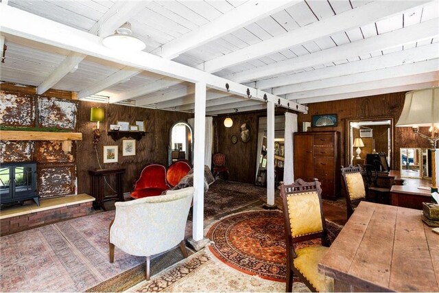 living room featuring beam ceiling and wooden walls