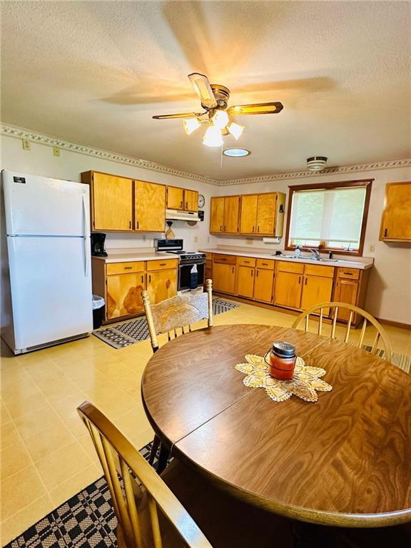 dining space featuring a textured ceiling and a ceiling fan