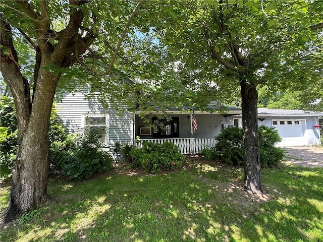 view of front of property featuring a garage, a front yard, and covered porch