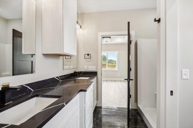 bathroom featuring double vanity, tile patterned floors, and a shower