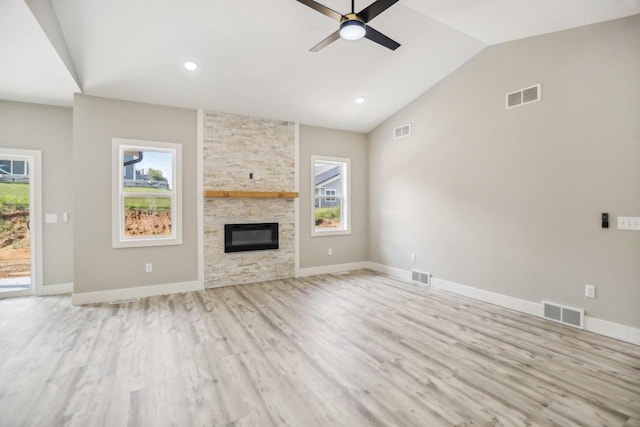 unfurnished living room with a fireplace, light wood-type flooring, ceiling fan, and lofted ceiling