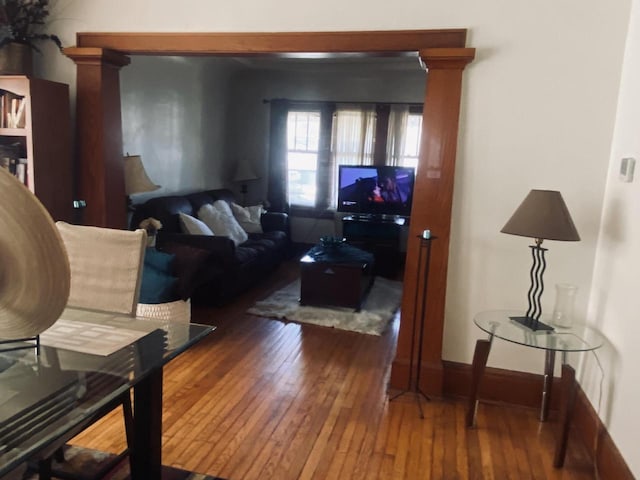 living room featuring decorative columns and hardwood / wood-style floors