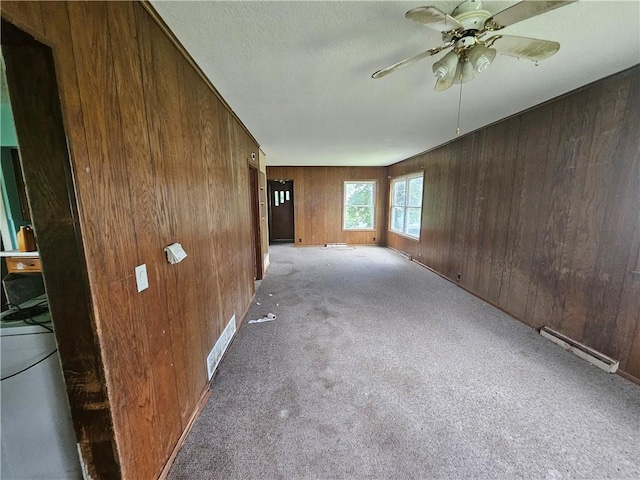 interior space featuring a baseboard radiator, carpet flooring, and wooden walls