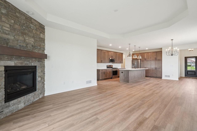 502 Hickory Hollow Rd Unit 0101, Waterford, WI 53185 - unfurnished living room with a raised ceiling, a chandelier, a large fireplace, light wood-type flooring, and recessed lighting