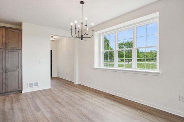 502 Hickory Hollow Rd Unit 0101, Waterford, WI 53185 - unfurnished dining area with a chandelier, light wood-type flooring, and baseboards