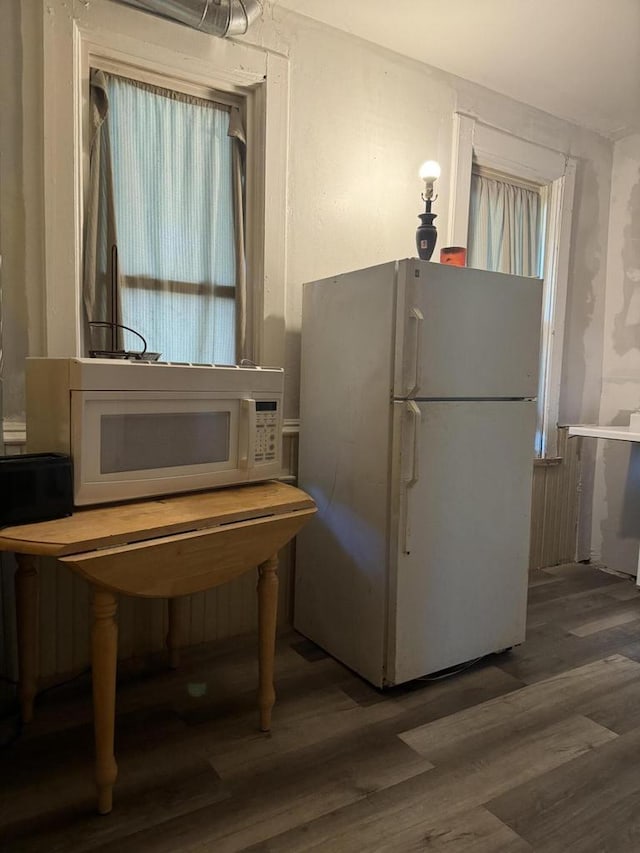 kitchen with dark wood-type flooring and white appliances