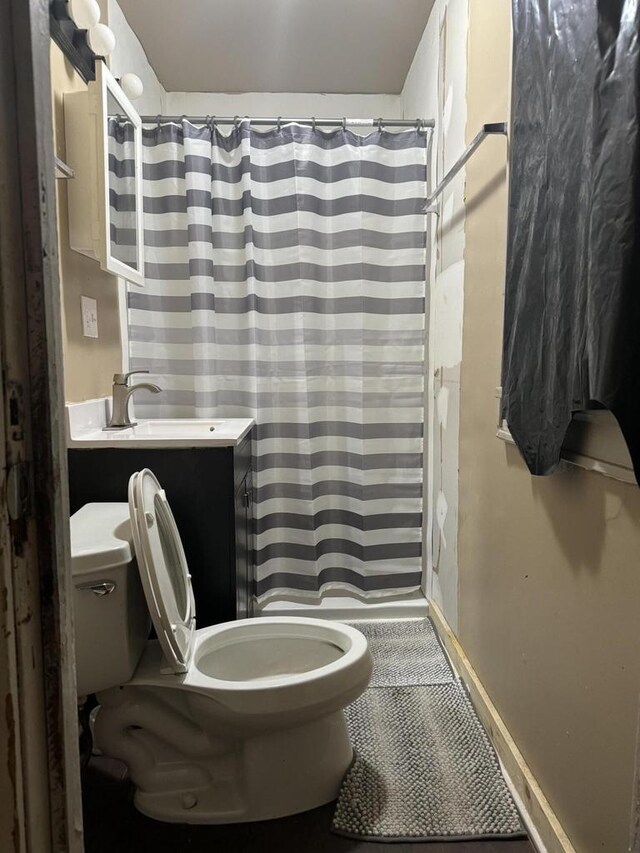 bathroom with toilet, vanity, and walk in shower