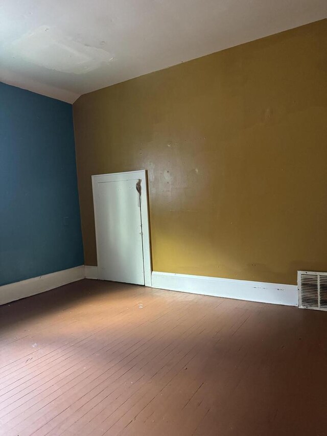 empty room featuring hardwood / wood-style floors and lofted ceiling