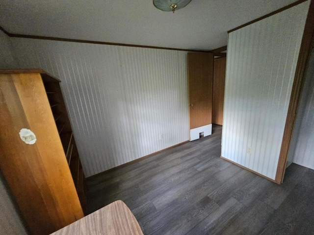 spare room featuring dark hardwood / wood-style flooring and crown molding